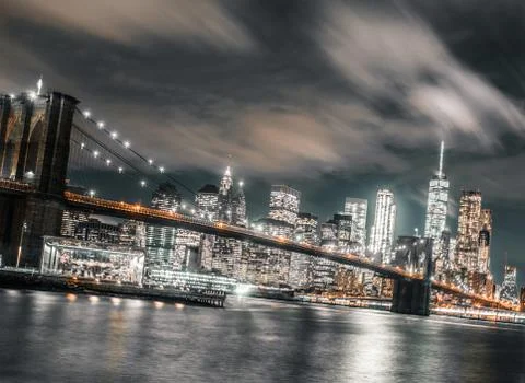Long exposure wispy clouds dominate the brooklyn bridge and downtown Manhatta Stock-Fotos