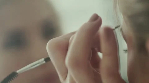 Long eyelashes side. Make-up artist puts his eyebrows model Stock Footage 68051267