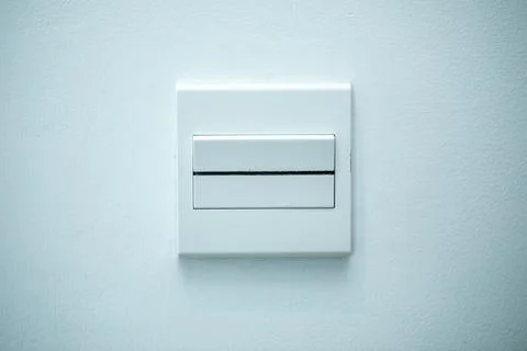 Long flat white on-off switch attached to white wall. White background. Stock Photos