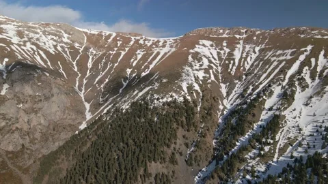 Long flight towards a high beautiful mountain with snow on top on a sunny day Stock Footage 168840104