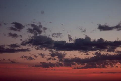 Long fluffy clouds in the evening in warm weather shimmering Stock Photos