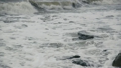 A long foamy wave rolls to shore slow motion Stock Footage 81403441