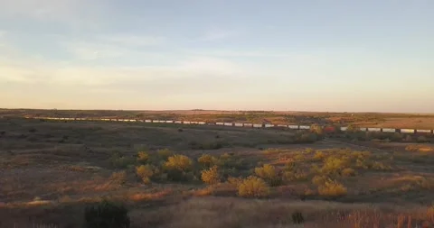 Long Freight Train with Cargo Driving through plains in America Vídeo Stock 135874493