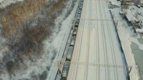 Long freight train coming on the railroad station at sunset in winter. Aerial 스톡 동영상 126360279