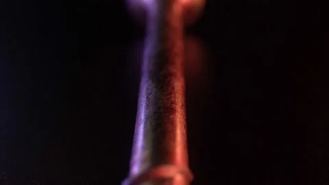 A long galvanized screw is placed on the dark surface of the table. The concept Stock Footage 160111052