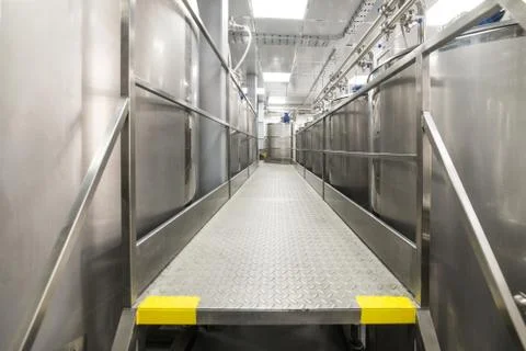A long gangway between two rows of cisterns. Storage of food liquids. Stock Photos