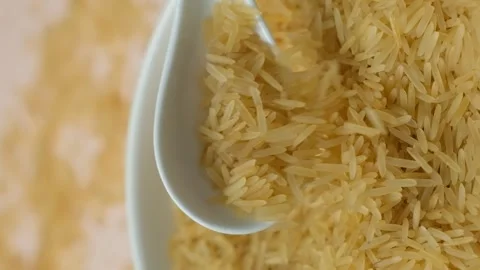 Long grain parboiled basmati rice pouring with spoon macro vertical slow motion Stock Footage 268441723