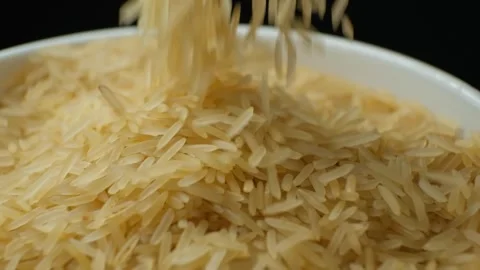 Long grain parboiled basmati rice pouring on black background, slow motion Video stock 268472389
