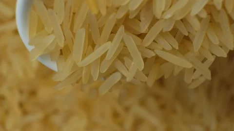 Long grain parboiled basmati rice pouring with spoon macro slow motion Stock Footage 269679792