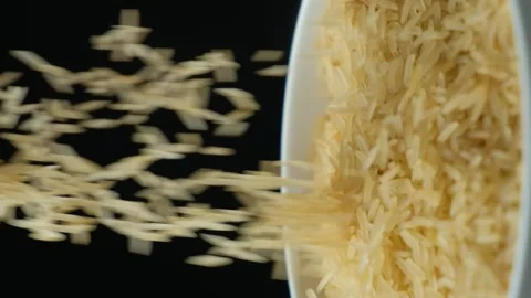 Long grain parboiled basmati rice pouring on black background, vertical slow Stock Footage 269680481