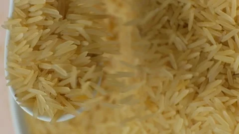 Long grain parboiled basmati rice pouring with spoon macro vertical slow motion Stock Footage 271229264