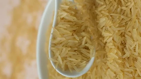 Long grain parboiled basmati rice pouring with spoon macro vertical slow motion Stock Footage 272215862