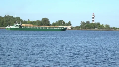 Long green loaded container ship crosses wide blue river Stock Footage 113091091