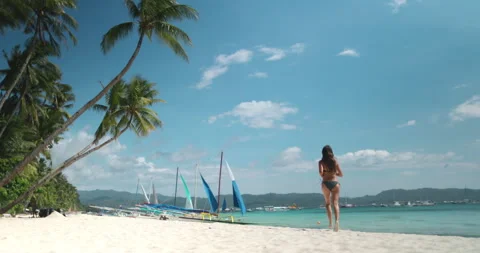 Long hair girl in bikini running white sand beach Stock Footage 252194953