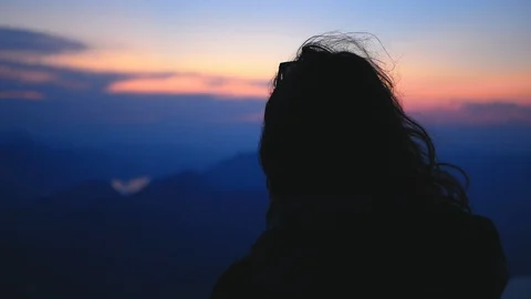 Long hair hiker girl at viewpoint watching sunset at blue hour. Wind Stock Footage