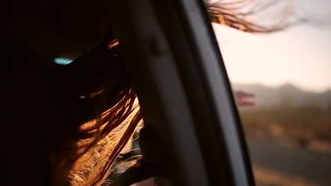 Long hair of a young beautiful girl flutter on the wind from the car window Stock Footage