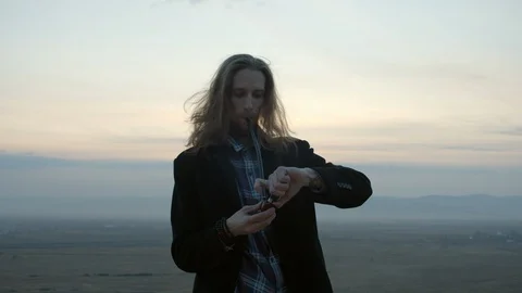Long haired bearded guy smoking a pipe in the sunset in siberia Stock Footage 129209813