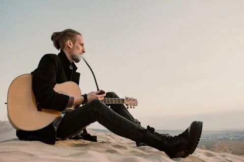 Long haired bearded guy smoking pipe in the sunset Stock Photos
