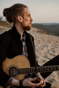Long haired bearded guy smoking pipe in the sunset Stock Photos