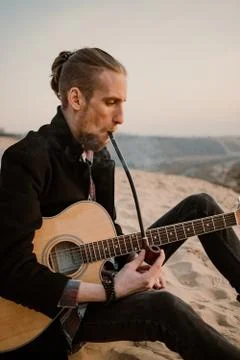Long haired bearded guy smoking pipe in the sunset Stock Photos