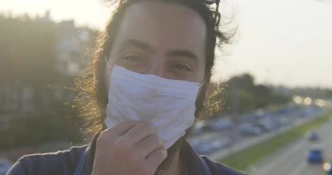 Long haired, bearded young handsome man is wearing face mask and smile. Prote Video stock 139298783