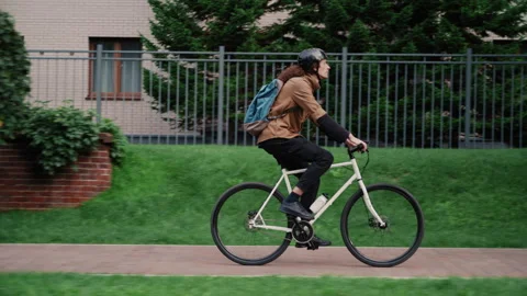 Long-Haired Biker Rides Through Well-Maintained Neighborhood 库存影片 317562268