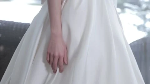 Long haired blonde tries on elegant white silk wedding dress Stock Footage 132700917
