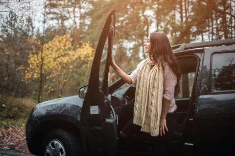 Long-haired brunette on the auto background. A female model is wearing a sweater Foto stock