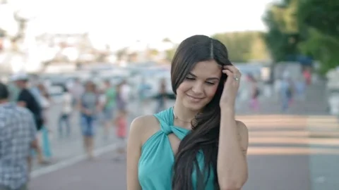 Long-haired brunette weared in the blue dress walking around the city Stock Footage 78592841