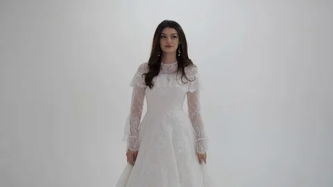 Long haired brunette in white wedding dress poses for camera Stock Footage 126597464