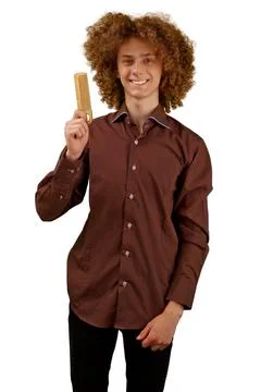 A long-haired curly-haired guy in a brown shirt on a white background uses a  Stock Photos