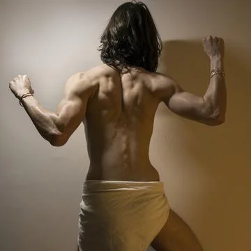 Long haired male model flexing muscles Stock Photos