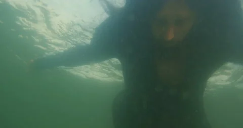 Long-haired man in black clothes falls into the water and drowns 動画素材 145922633