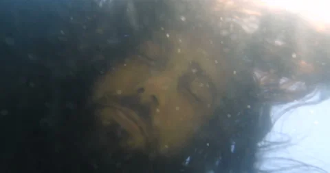 Long-haired man in black clothes falls into the water and drowns 動画素材 145922707