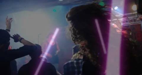 Long-haired man headbanging to music beat in concert, purple light streaks Stock Footage 321890239