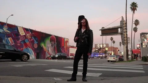 Long Haired Man with Leather Jacket standing on Sunset at dusk Hendrix Hollywood Stock Footage 124668013