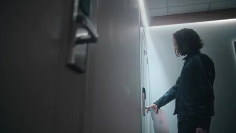 A long-haired man opens the door of a hotel room by applying an access card to Stock Footage 252274272
