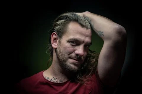 Long-haired man posing sexy and seductive in front of the camera. Stock Photos