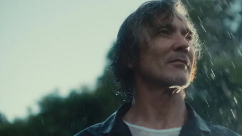 Long haired man standing in the rain Stock Footage 279061383