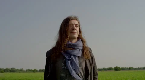 Long haired man walks through rice field Stock Footage 63082531