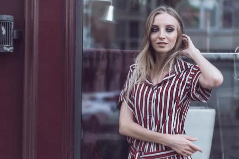 Long-haired model poses outside vintage cafe Foto stock