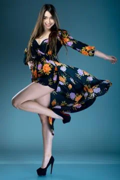 Long-haired model posing in black bikini with pareo or beach robewith floral  Stock Photos