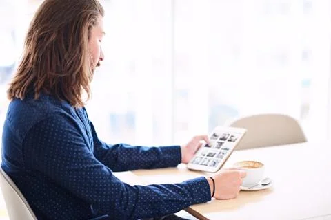 Long haired modern man with tablet sitting next to window Stock Photos