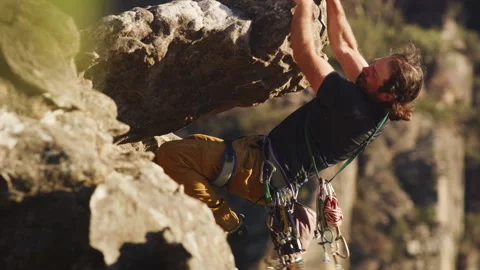 A Long-haired rock climber holding onto a rock Stock Footage 264138713