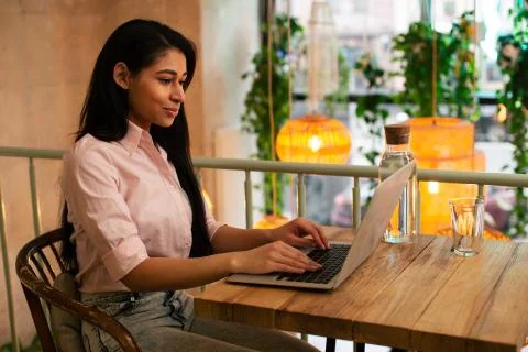 Long haired student working on her laptop and smiling Stock Photos