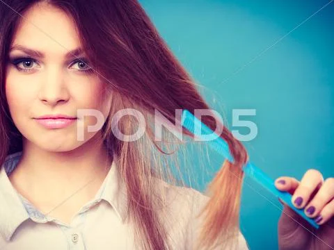Long haired woman combing her hair. Stock Photos