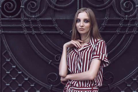 Long-haired young model poses on metal door background 스톡 사진