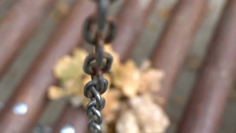 A long, hanging, rusty chain gently heaving. Shot from above with a small depth  Stock Footage 106530464