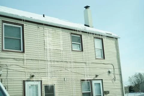 Long icicles on front of the house. Stock Photos