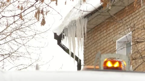 Long icicles hang on long icicles hang on the roof of the house Stock Footage 147674522